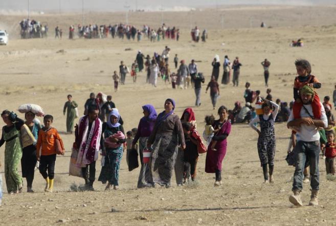 Mujeres, hombres y niños yazidíes huyen del IS en el norte de Irak.